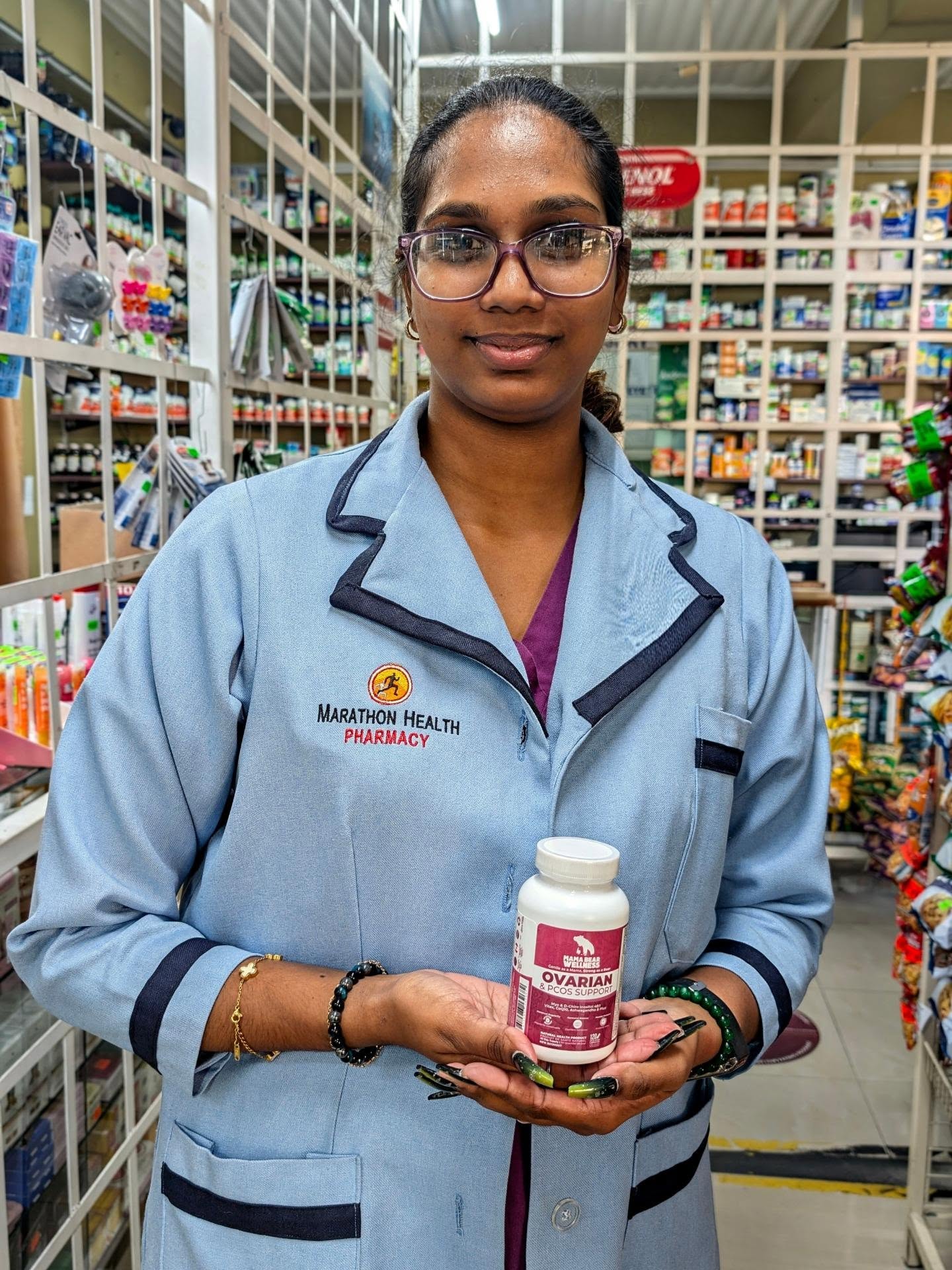 Pharmacist at Marathon Health Pharmacy in Trinidad holding Mama Bear Ovarian & PCOS Support in front of the dispensary